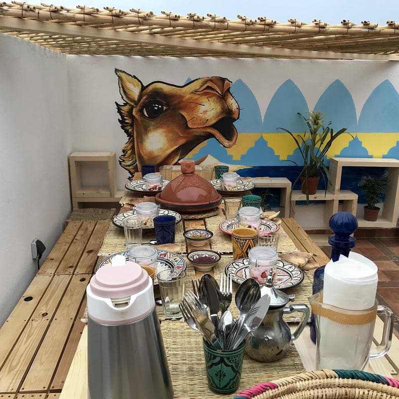 Breakfast and tagines laid out on the rooftop table
